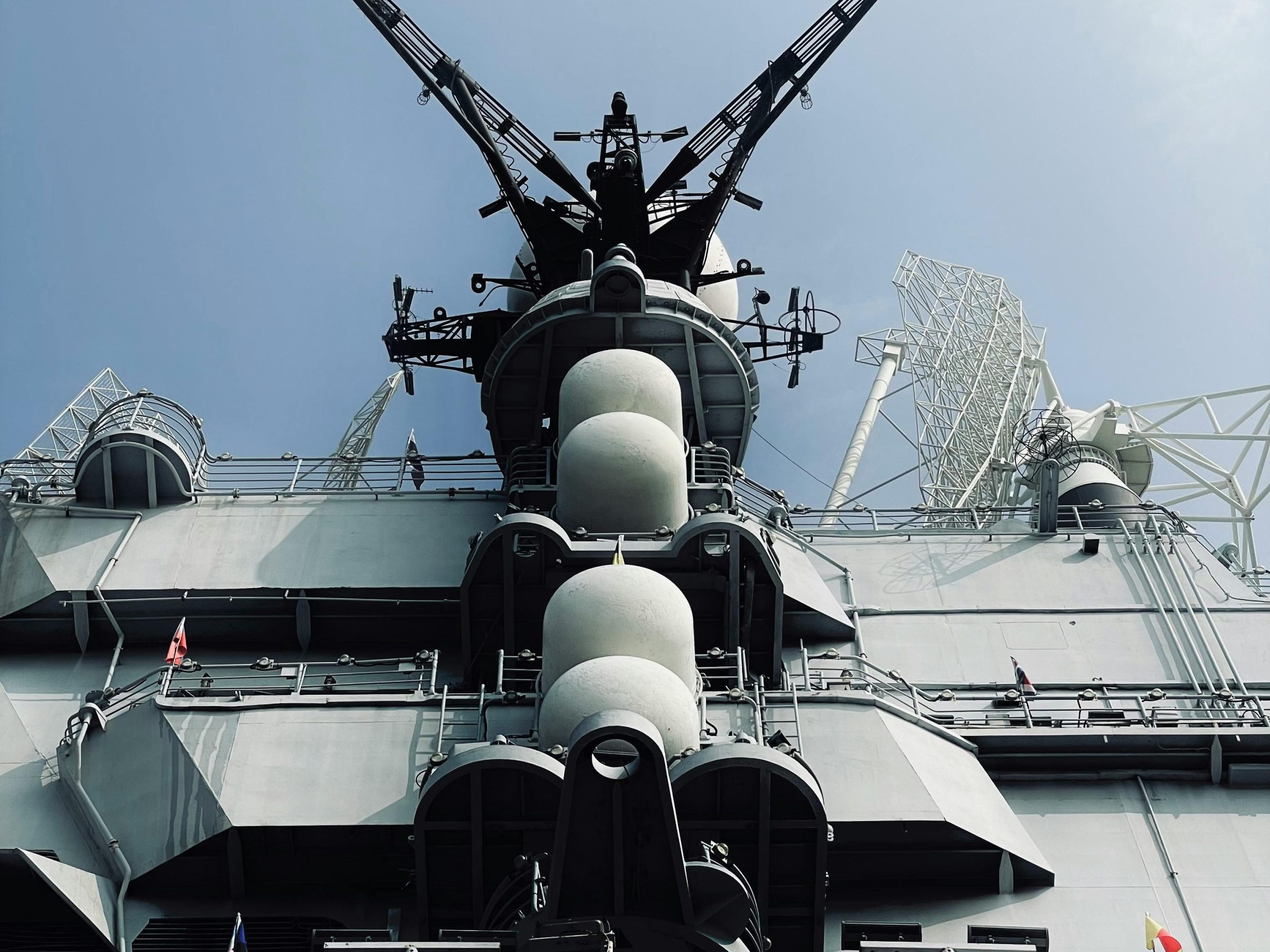 Low angle view of a military navy ship under a clear sky, symbolizing strength and power.