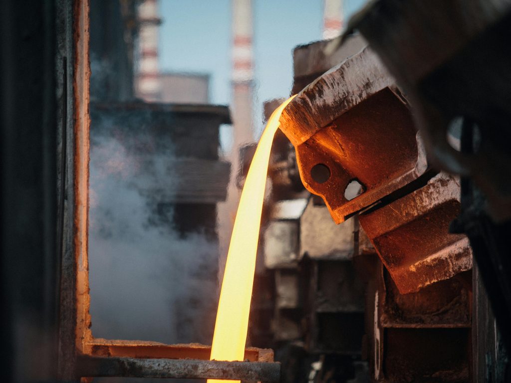 Close-up of molten metal pouring in a foundry, showcasing industrial processes.