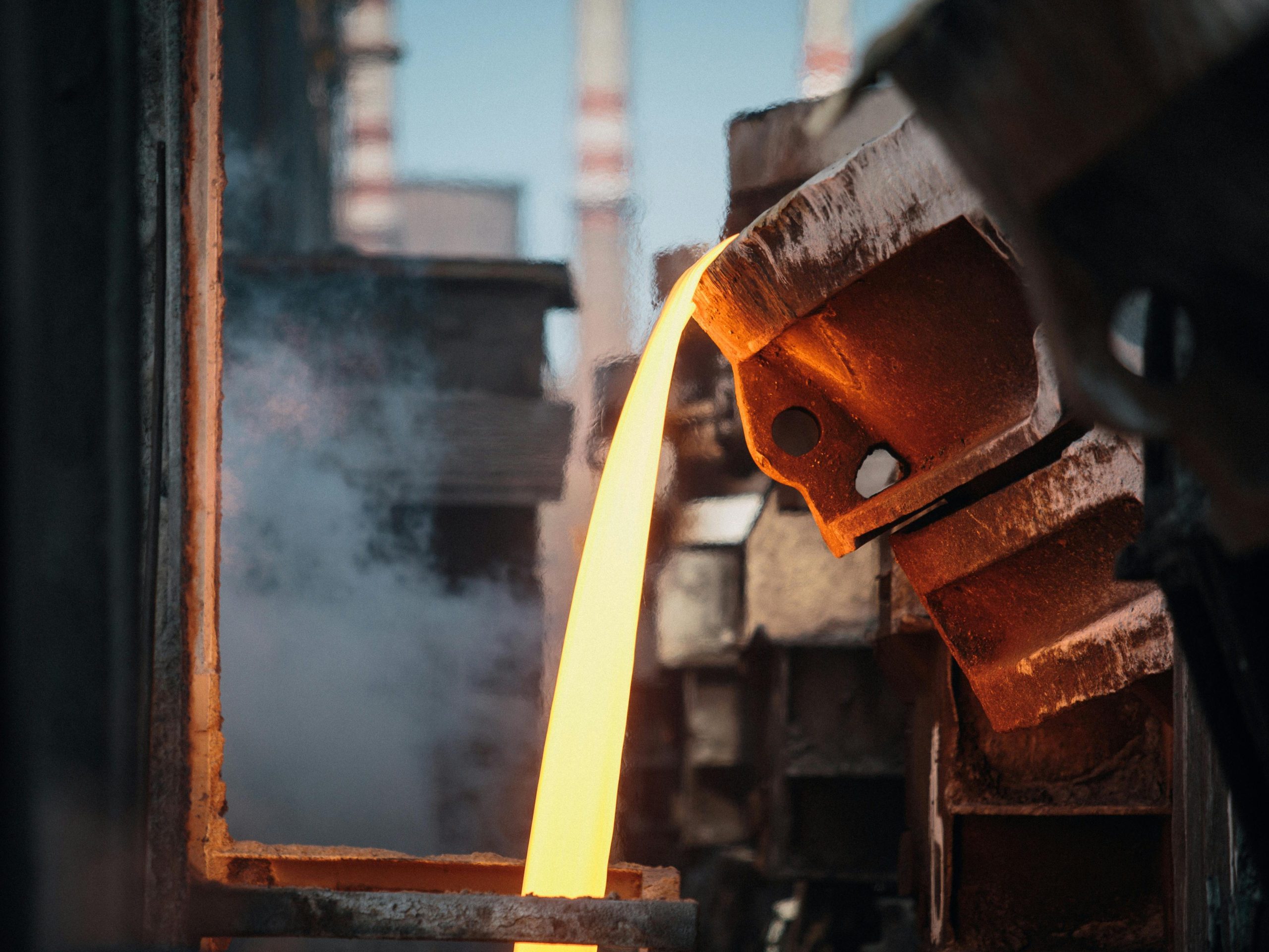 Close-up of molten metal pouring in a foundry, showcasing industrial processes.
